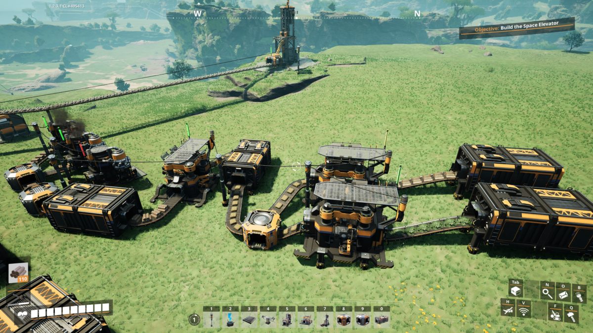 A sprawling early Satisfactory factory of machines placed on bare grass