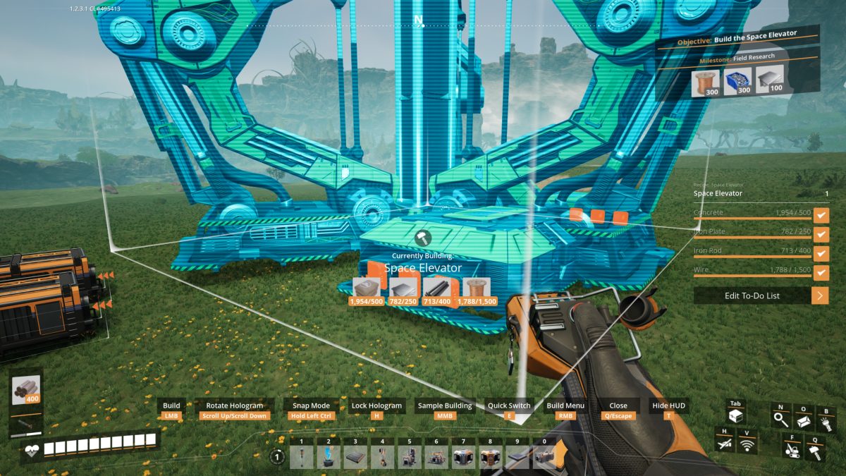 The translucent Space Elevator placement hologram towering over the factory in Satisfactory