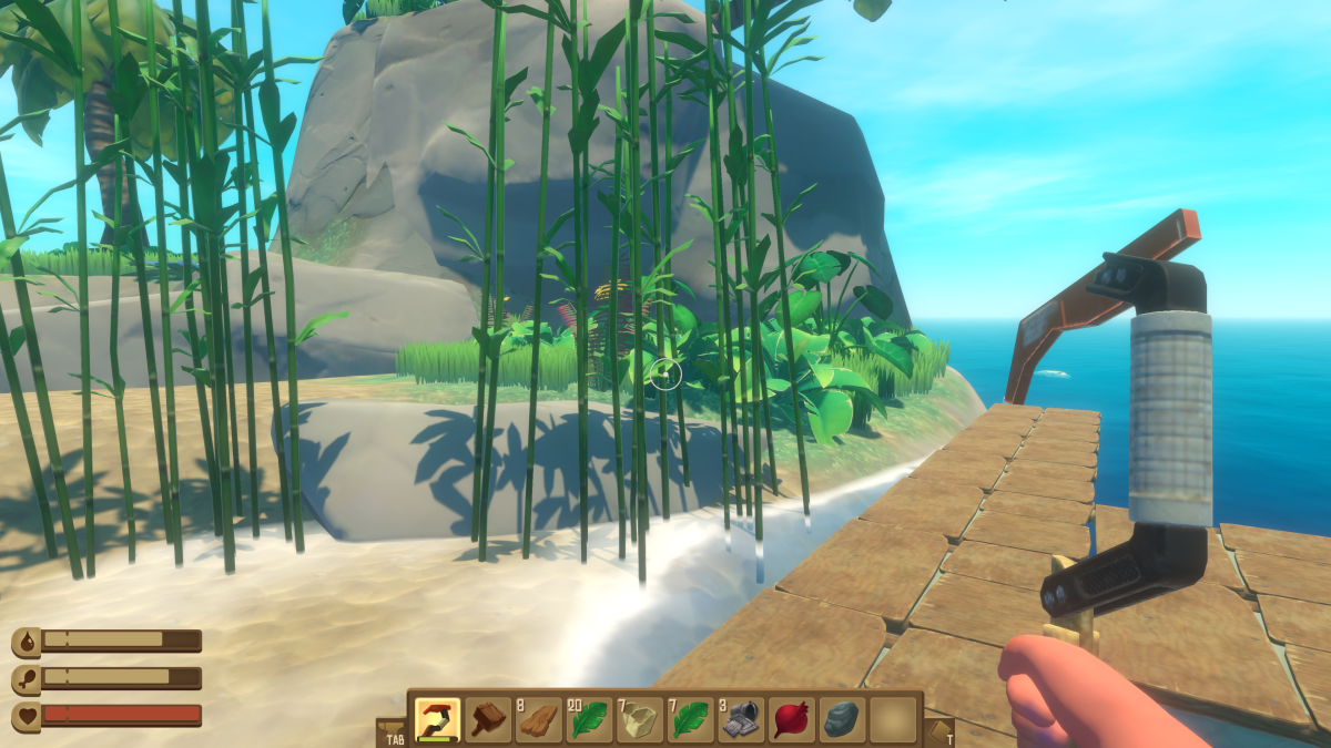 The raft pulled up alongside a small tropical island with a beach, rocks, palm trees and bamboo in Raft
